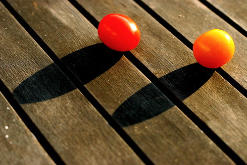 Two cherry tomatoes on a wooden table